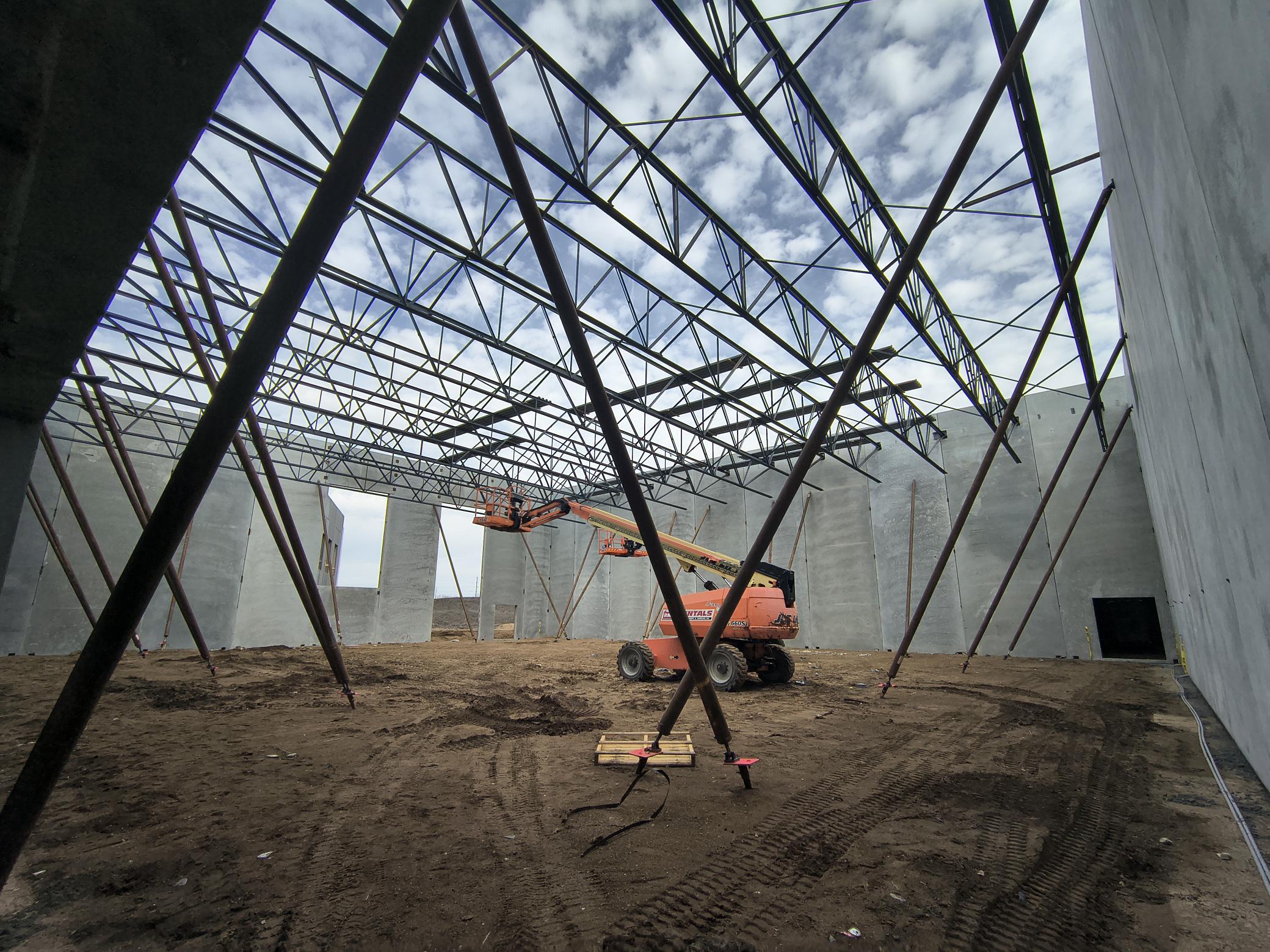 The steel roof joists and decking are being set in the Junior High gym. Once that is complete the bracing can come off the precast walls.